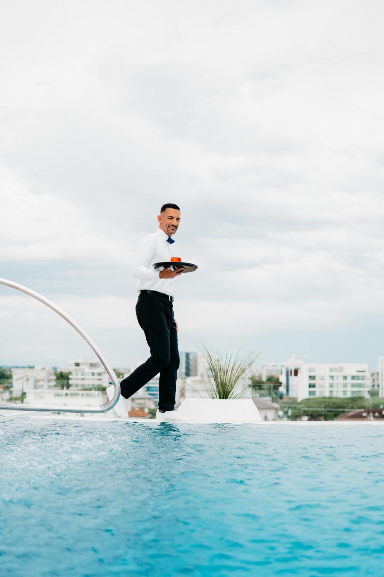 J44 Lifestyle Hotel Lido di Jesolo Eksteriør billede A waiter balancing on a tightrope